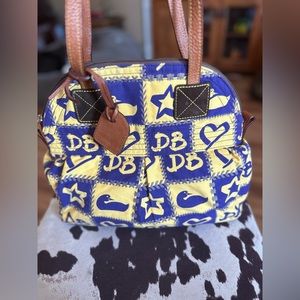 Authentic Dooney & Bourke shoulder bag with bright pink nylon material inside.